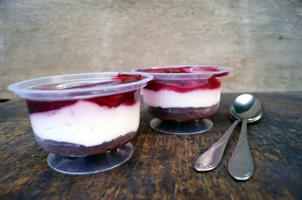 Парфайт десерт с ягодами, молочным суфле и желе. Лечение в стакане на деревенском деревянном фоне — стоковое фото