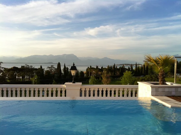 an infinity edge pool with the Lake Garda on the background