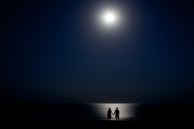 gece ay ışığında kıyıda Çift