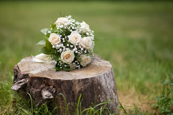 Wedding bouquet in the park on a stump — Stock Photo, Image