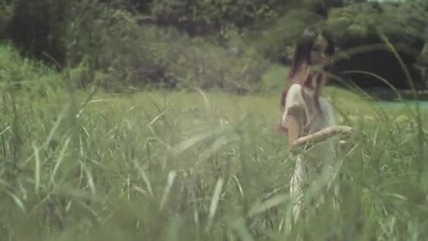 Een jonge vrouw lopen in riet — Stockvideo
