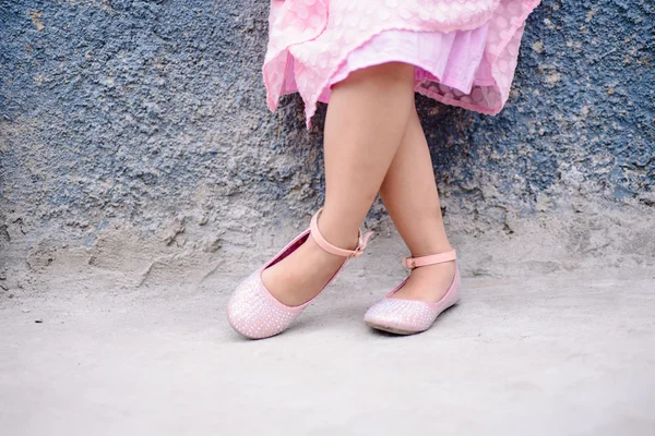 Little girl in crossed feet in lovely shoes — Stock Photo, Image