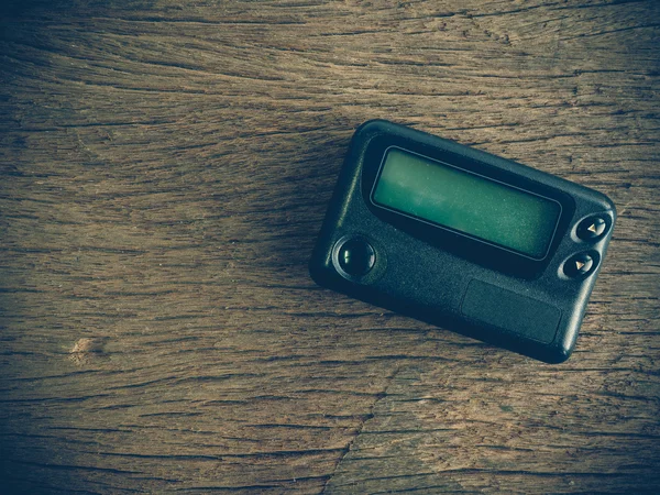 Old pager device on wooden table — Stock Photo, Image