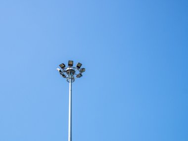 Mavi gökyüzü arkaplanındaki spot ışıkları direği