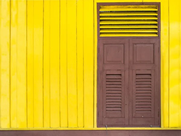 Janelas de madeira em um fundo amarelo — Fotografia de Stock