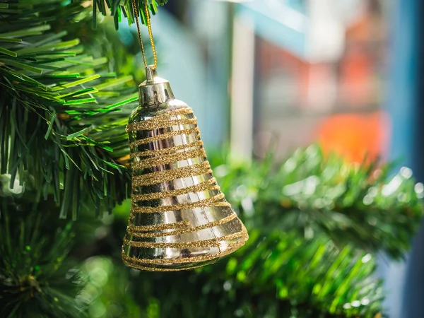 Golden ring bell hanging on Christmas tree with blur background,