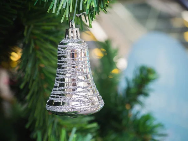 Ασημένιο δαχτυλίδι καμπάνα που κρέμεται από το χριστουγεννιάτικο δέντρο με θάμπωμα φόντου, — Φωτογραφία Αρχείου