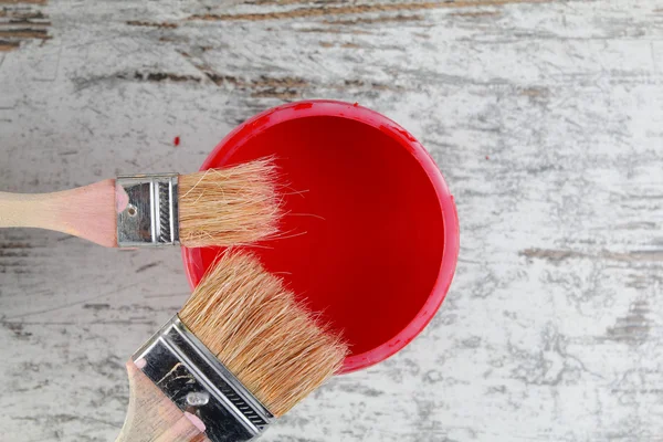 Verfborstels en verf kunnen in een houten achtergrond — Stockfoto