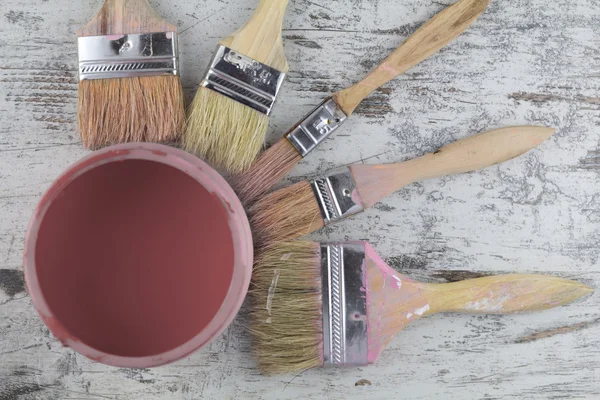 Paintbrushes and paint can in a wood background — Stock Photo, Image