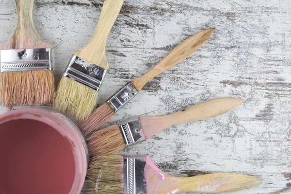 Paintbrushes and paint can in a wood background — Stock Photo, Image