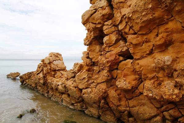 ビーチで、侵食された岩の壁 — ストック写真