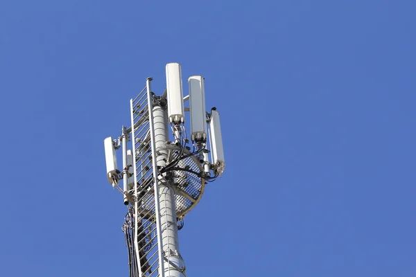 Şehirde birçok kuşlarda, mavi gökyüzü ile mobil antenler — Stok fotoğraf