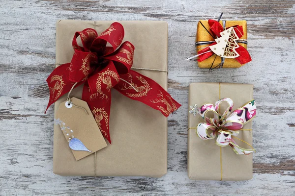 Gift boxes with ribbons, in a wood vintage background — Stock Photo, Image