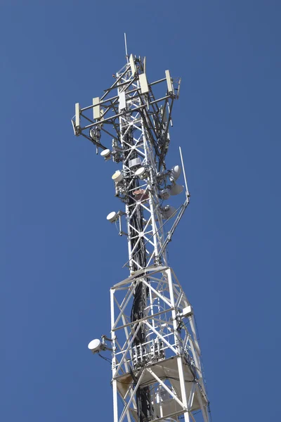 Telekomunikační věž proti modré obloze — Stock fotografie