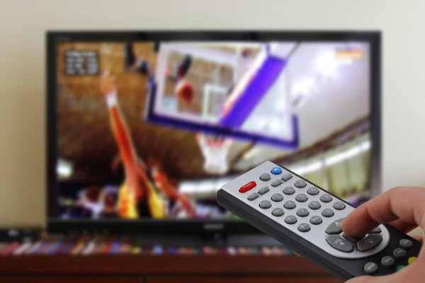 Remote control in the hand, during a basket match, sports