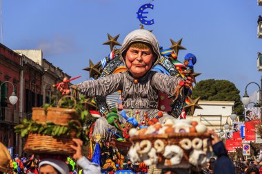 Putignano, Apulia, İtalya - 15 Şubat 2015: karnaval, yüzen dev kağıt mache. Avrupa siyasetçi: Angela Merkel. Karnaval Putignano: yüzer. Angela Merkel işkence Avrupa Topluluğu.