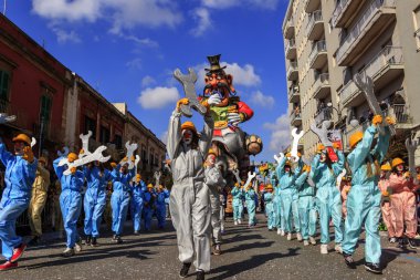 Putignano, Apulia, İtalya - 15 Şubat 2015: Karnaval, yüzen dev kağıt mache. Karnaval kostümü: Ilva sanayi alegorik kayan nokta.