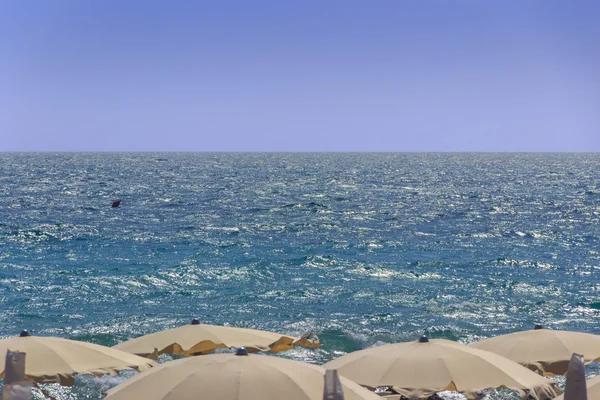 Estate: desiderio di mare. Horizon mare con gli ombrelloni eolici Puglia . — Foto Stock