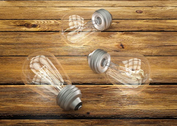 茶色の木製の背景にビンテージの電球  — 無料ストックフォト