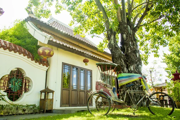 Chinese building architecture and old rickshaw in tree shade — Stock Photo, Image