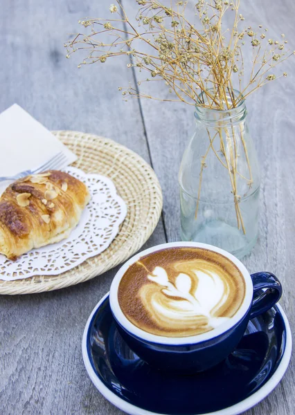 Frukost kaffe och mandel croissant på bord av trä — Gratis stockfoto