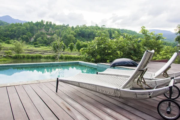 Resort zwembad en ligstoelen met bergzicht — Gratis stockfoto
