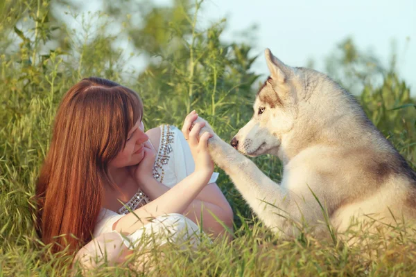 Молодая красивая девушка играет с собакой . — стоковое фото