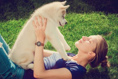 Genç kız bir köpekle oynamayı. Husky açık havada olan köpek yavrusu Sibirya Husky.Beautiful kadın. Sibirya husky köpek, güneşli bir günde bir yürüyüş ile köpek oturan gülümseyen kadın.
