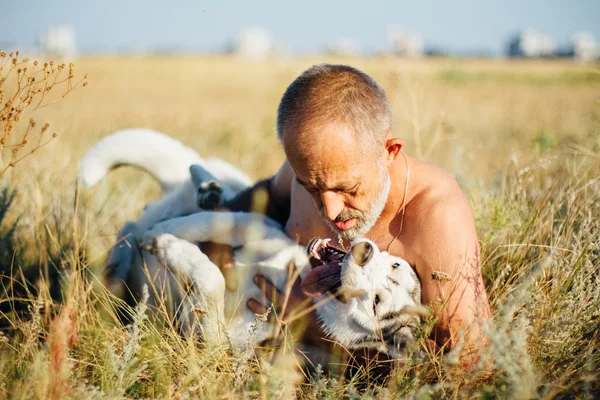 Старик играет со своей собакой Сибирской Хаски. Стиль жизни. Активный отдых . — стоковое фото