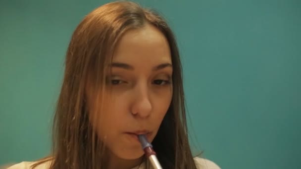 Молодая девушка курит кальян в голубой комнате — стоковое видео