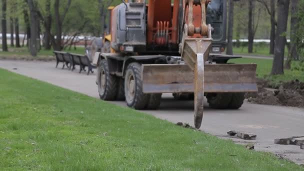 Grävmaskin extraherar trottoarkanten av vägen — Stockvideo