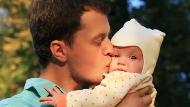 Молодой отец целует свою счастливую дочь — стоковое видео