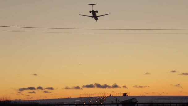 Αεροπλάνων που προσγειώνονται στο αεροδρόμιο κατά τη διάρκεια του ηλιοβασιλέματος — Αρχείο Βίντεο
