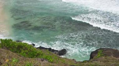 Uçurumun kenarından sersemletici bir okyanus manzarası, Açık Sığ 'ı, Çarpıcı Sörf' ü ve tenha bir plajın engebeli güzelliğini vurguluyor..