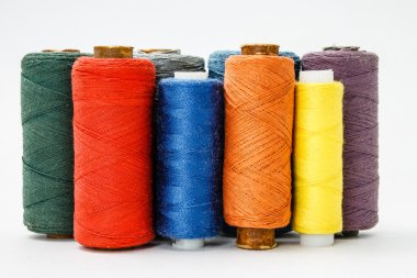 Beyaz arkaplanda renkli iplik makaraları