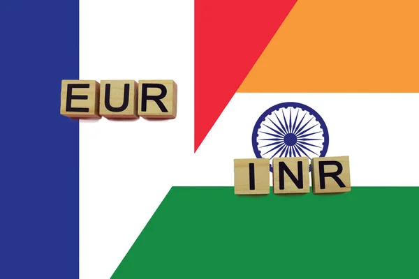 France and India currencies codes on national flags background. International money transfer concept
