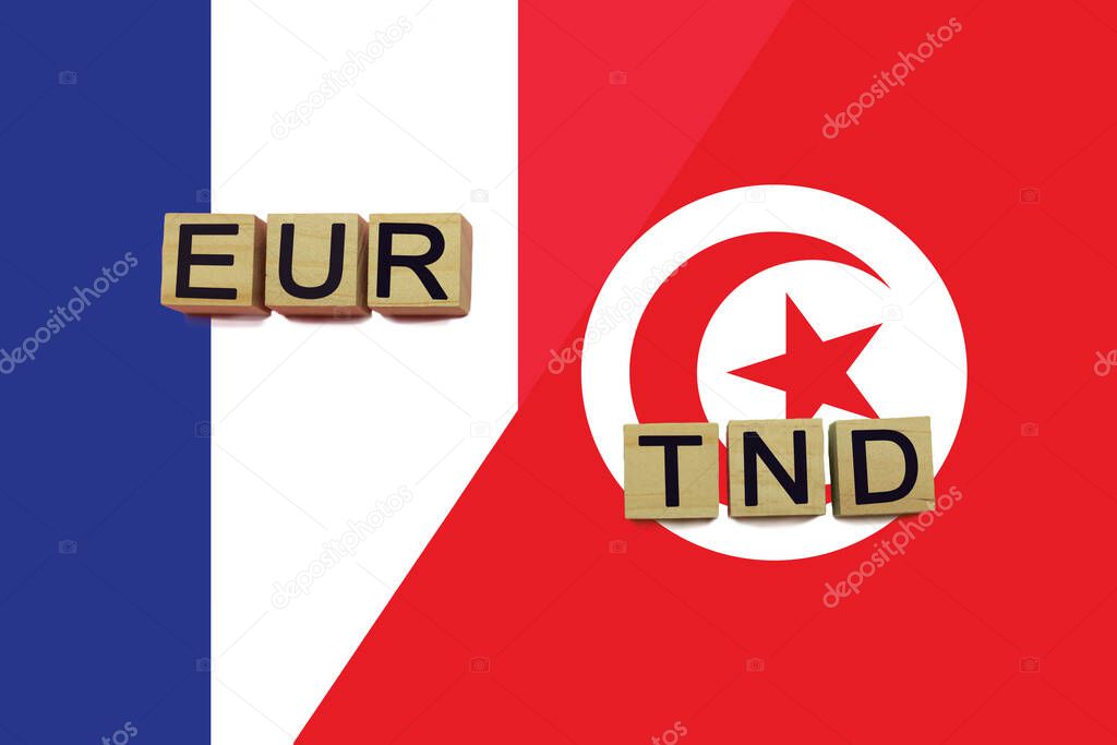 France and Tunisia currencies codes on national flags background. International money transfer concept
