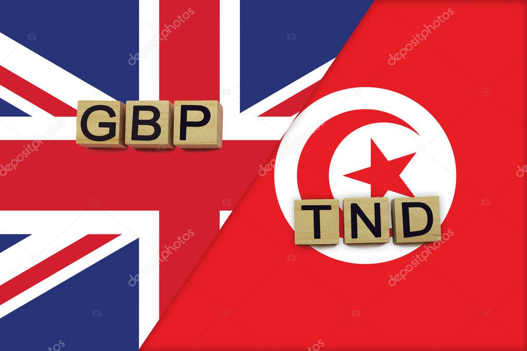 United Kingdom and Tunisia currencies codes on national flags background. International money transfer concept
