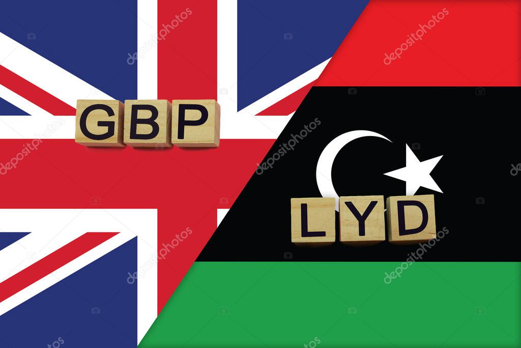 United Kingdom and Libya currencies codes on national flags background. International money transfer concept