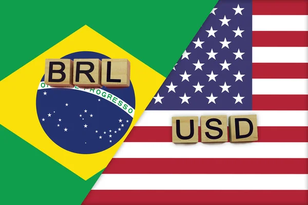 Brazil and USA currencies codes on national flags background. International money transfer concept