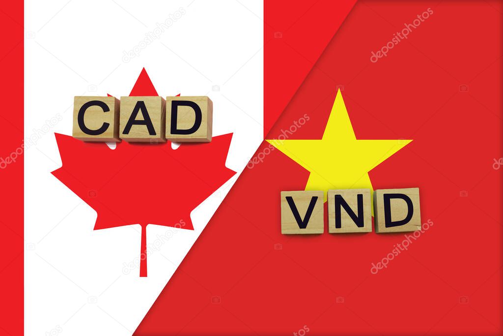 Canada and Vietnam currencies codes on national flags background. International money transfer concept