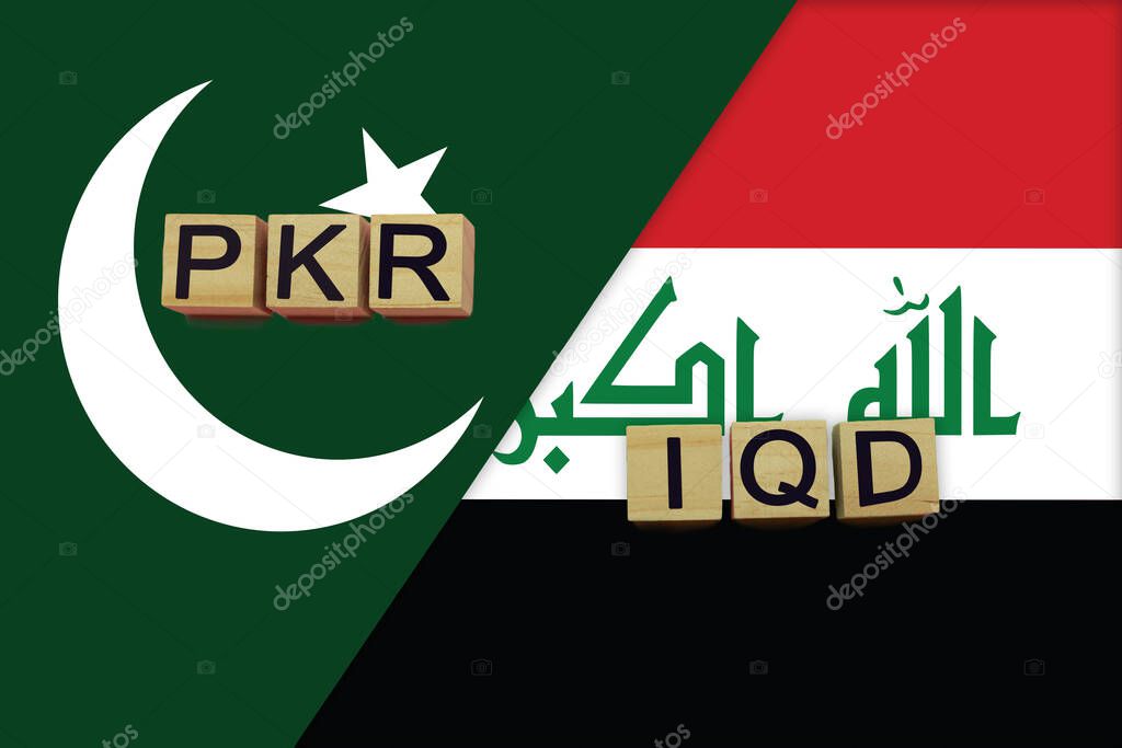 Pakistan and Iraq currencies codes on national flags background. International money transfer concept