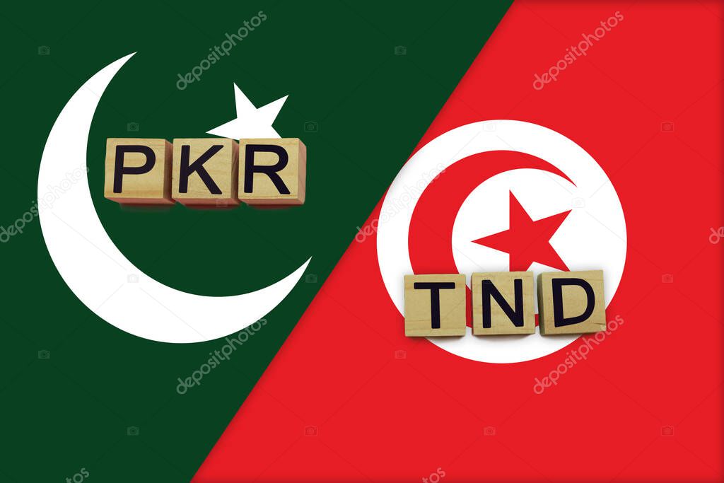 Pakistan and Tunisia currencies codes on national flags background. International money transfer concept