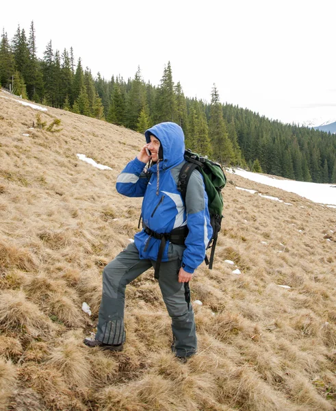 Caminante hablando en el teléfono inteligente en las montañas de invierno — Foto de Stock