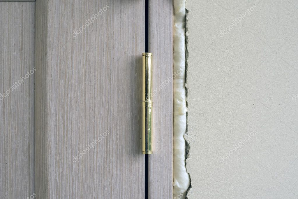 Installation of doors using polyurethane foam mounting. Stock Photo by