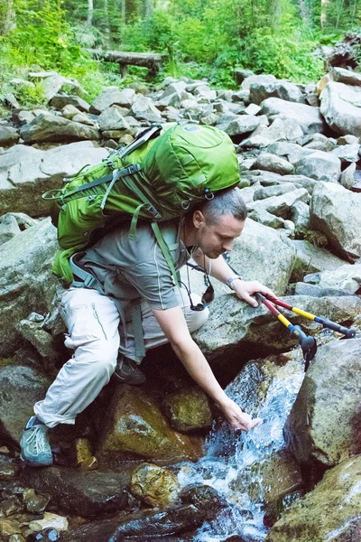 Uzun yürüyüşe çıkan kimse içme suyu ile dere.