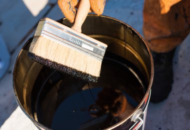 Su yalıtımı için bir araç. Çatı ustası temel Beton kapak, polimer modifiye bitüm astar su yalıtım. Bir alt kapak beton, Bitüm-Kauçuk astar fırça.