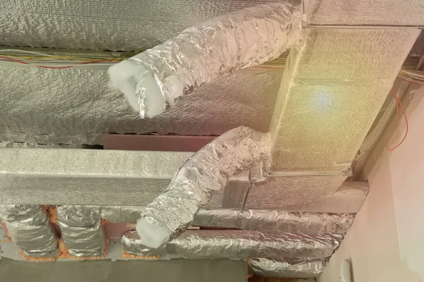 Tavanda gümüş yalıtım malzemeleriyle havalandırma boruları — Stok fotoğraf