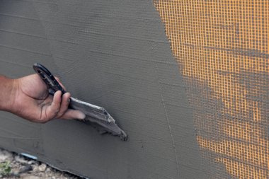 Fiberglas ağ takviye ızgarası kurma işlemi. İşçi fiberglas ağ kuruyor.