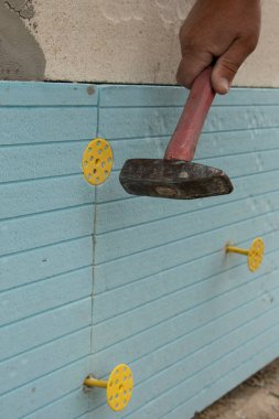 İzolasyon kurulumu polistiren paneller çıkardı. İşçi Genişletilmiş polistiren paneller kuruyor.